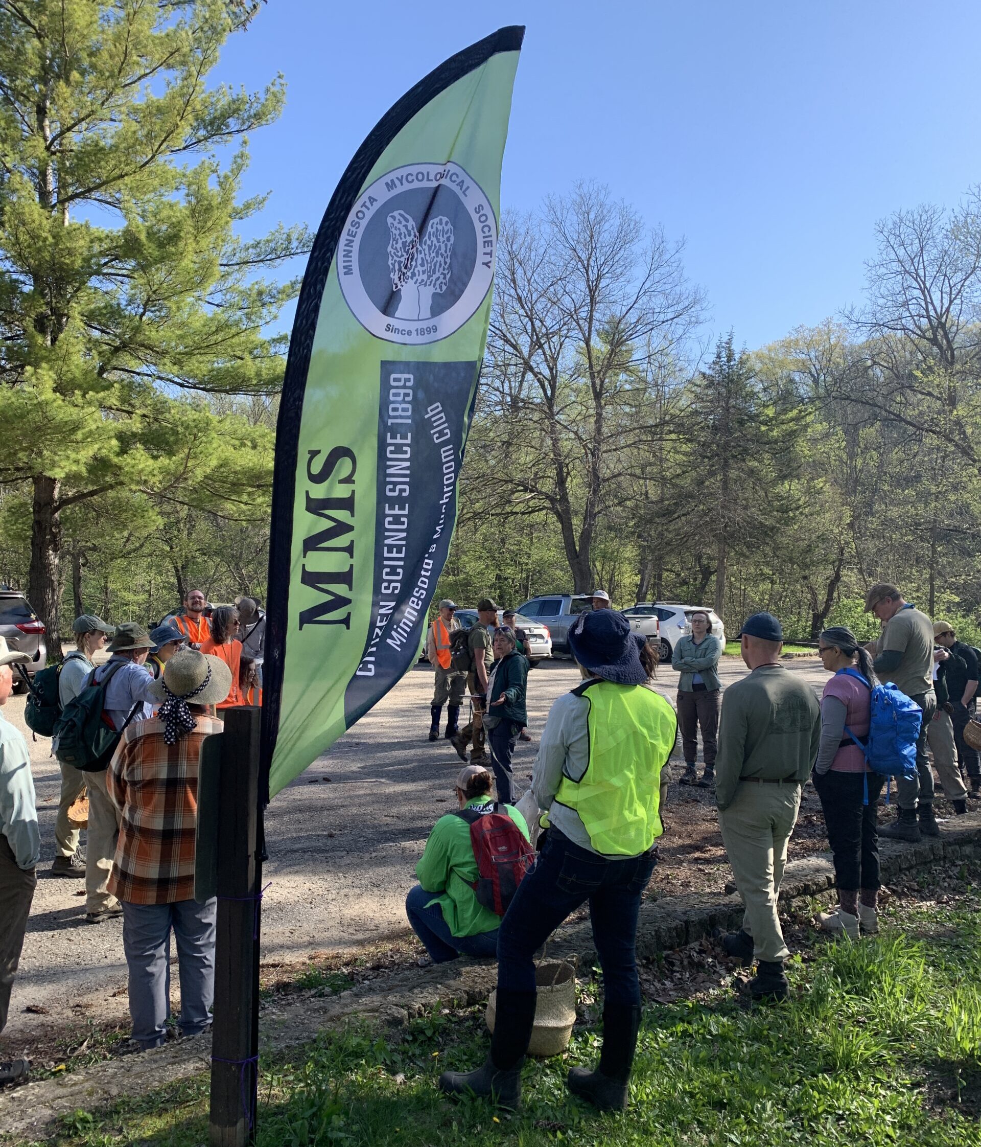 MMS members gathered at the beginning of a 2025 spring foray listening to a foray leader making providing pre-foray instructions and safety info.