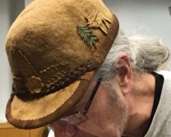 Honorable Mention 4 - (2 of 2) Man wears a handcrafted hat made from amadou, decorated with natural embellishments like a pine needle motif and braided trim, earning an Honorable Mention in a photo contest